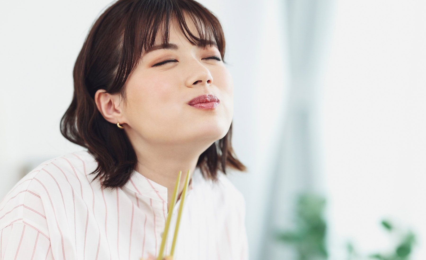 食事しながら笑顔の女性イメージ画像